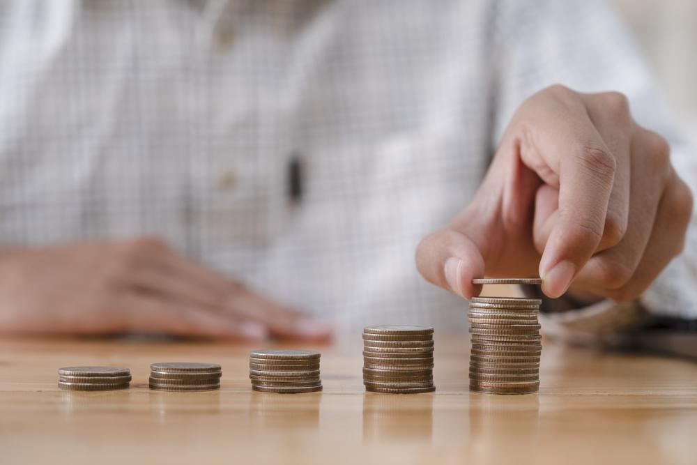 person stacking money they are saving