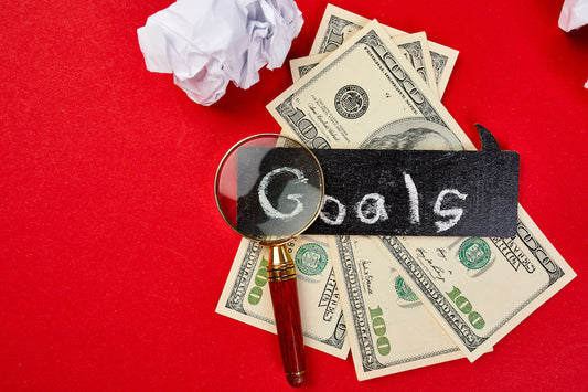 defining your long term financial goals with money and magnifying glass
