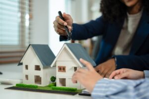 Woman explaining features of model home to a person