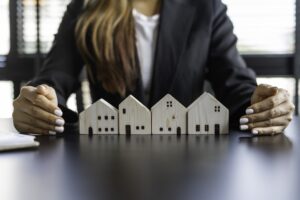 Woman with arms around wooden homes in a row
