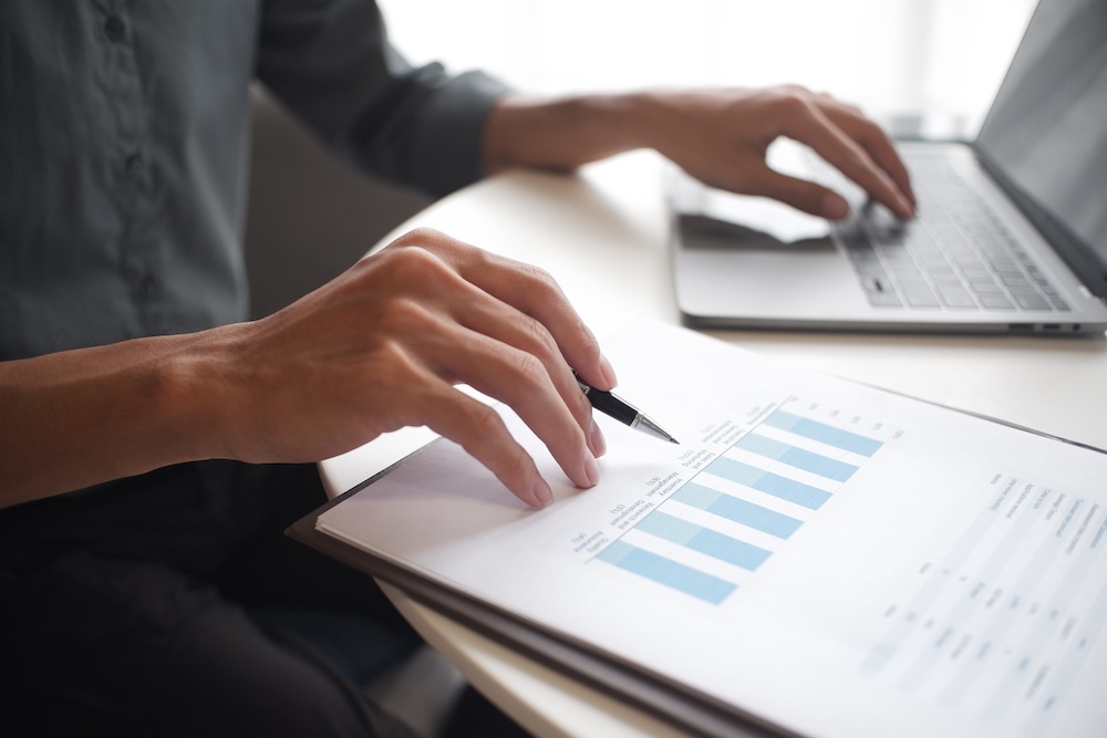 Close up of a woman tracking her financials on a laptop