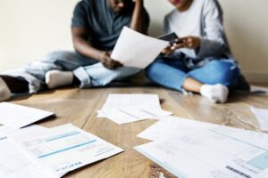 Couple sitting on floor looking at finances and bills