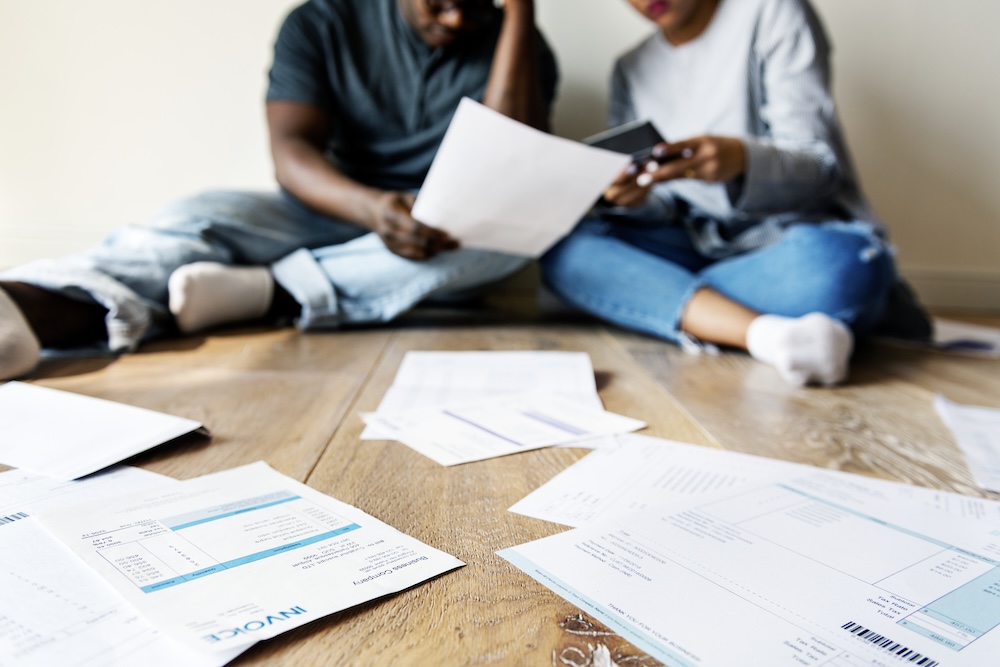 Couple sitting on floor looking at finances and bills
