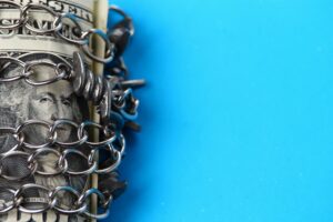 Money rolled up and wrapped in a chain