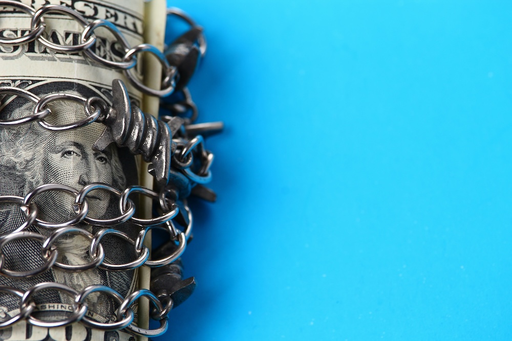 Money rolled up and wrapped in a chain