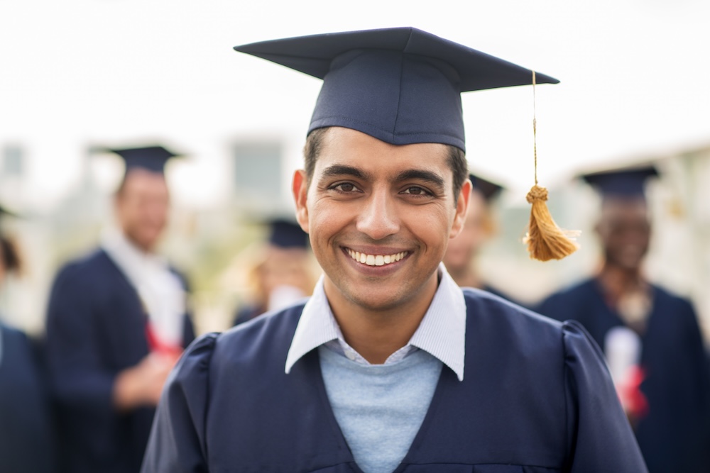 Student smiling after graduating with school mates