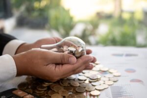 Businessman holding a lightbulb with coins inside