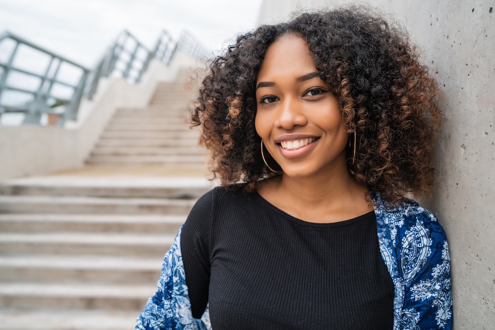 Young woman standing at the bottom of campus steps