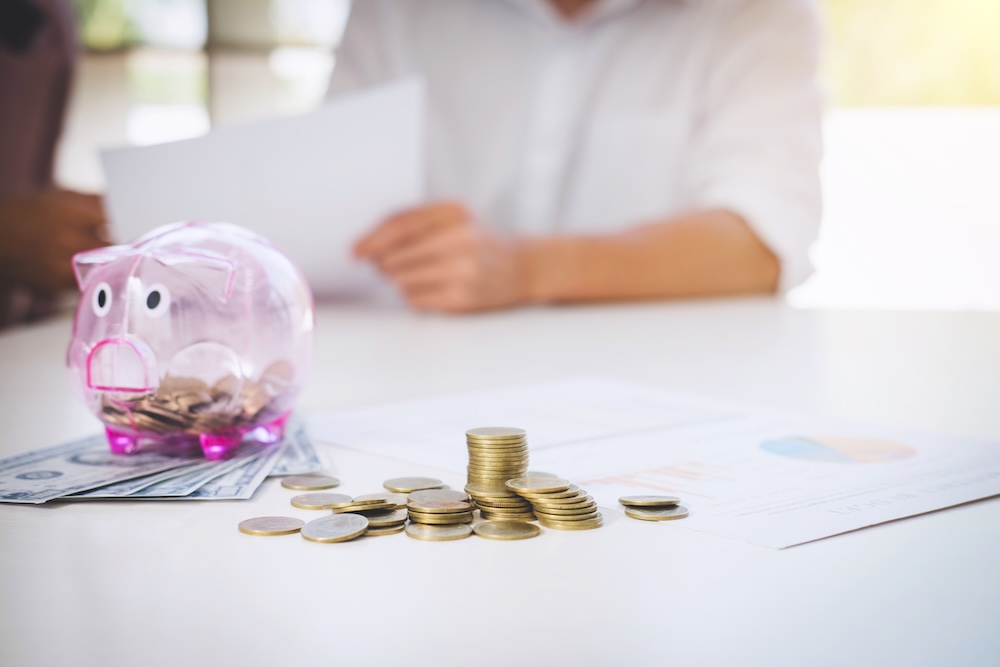 Couple putting money into a piggy bank