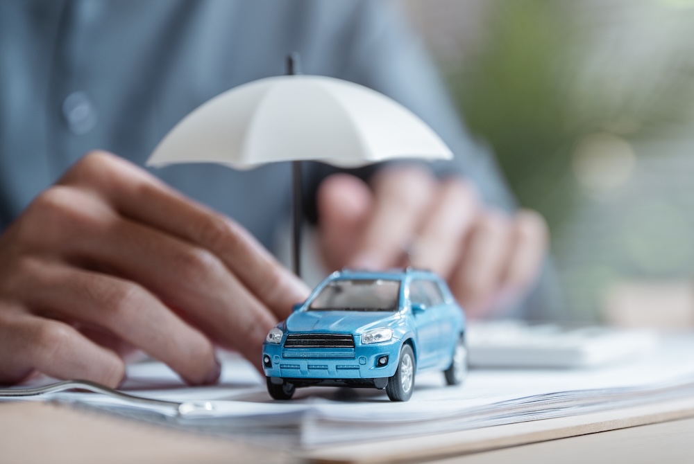 blue car with an umbrella sitting on a stack of papers