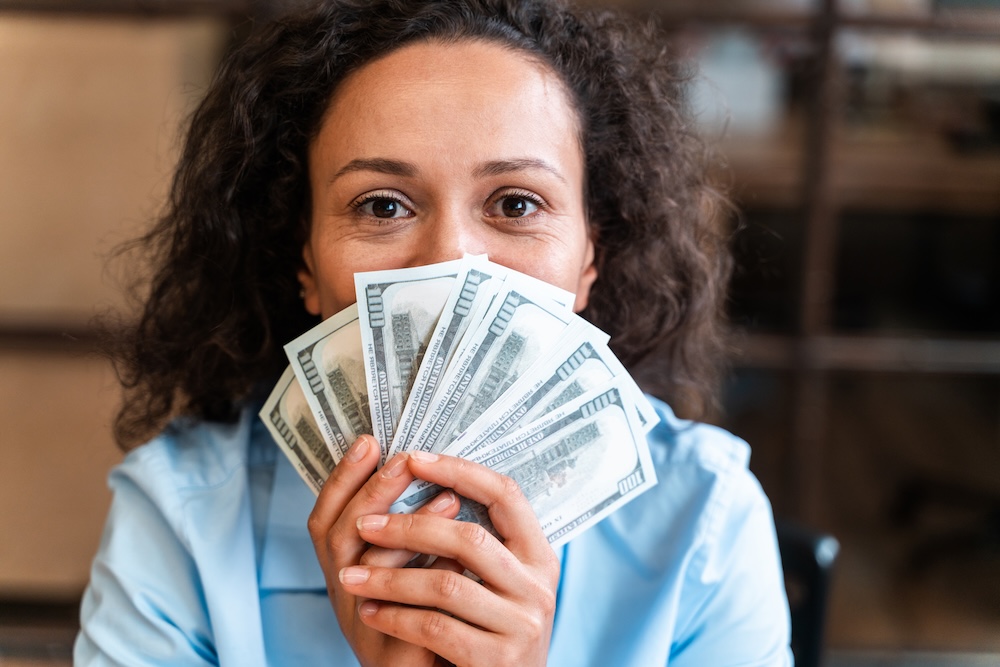 Business professional holding 100 dollar bills
