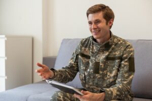Young military man holding a mobile device