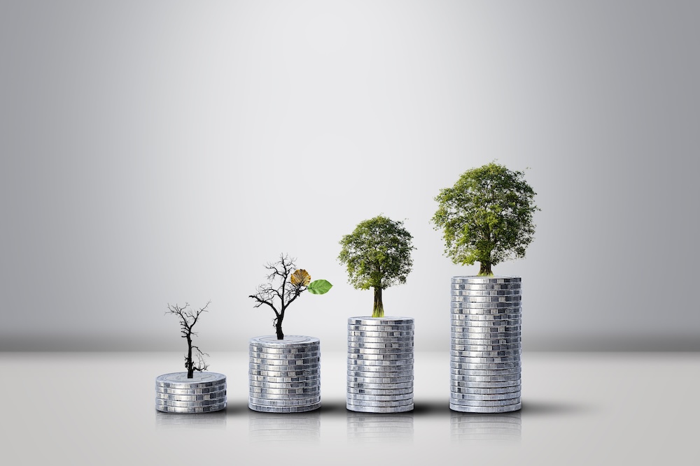 stacked coins with trees growing out of the top
