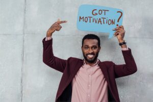 Man holding a sign that says Got Motivation