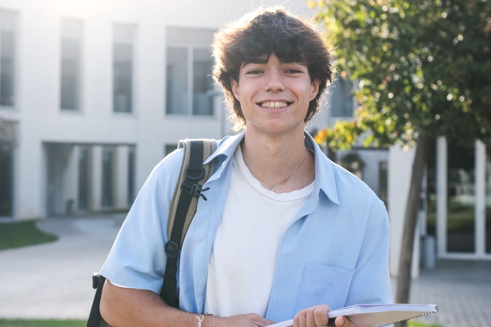 Young student holding books with backpack