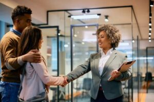 Couple shaking hands with a personal banking advisor.