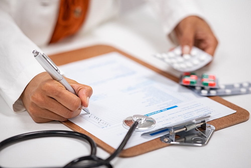 doctor writing up medical prescription and bill