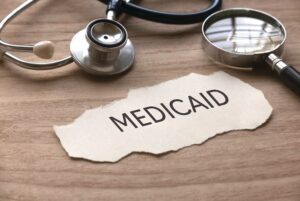 torn paper with medicaid with medical instruments