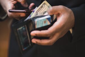 man looking at the money in his wallet