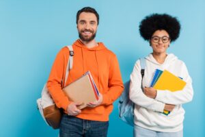 students holding books and supplies