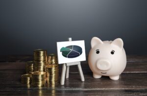 Stacked coins, a chart, and a piggy bank