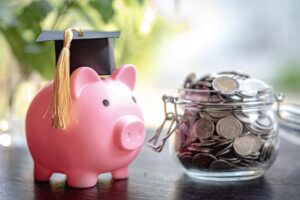 Piggy bank with a graduation hat and a jar of coins