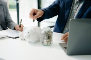 financial manager putting money in a penny bank