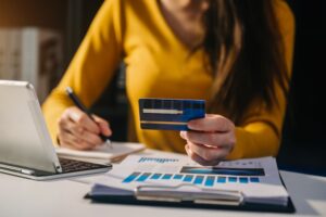 Woman using a mobile phone to pay with business card